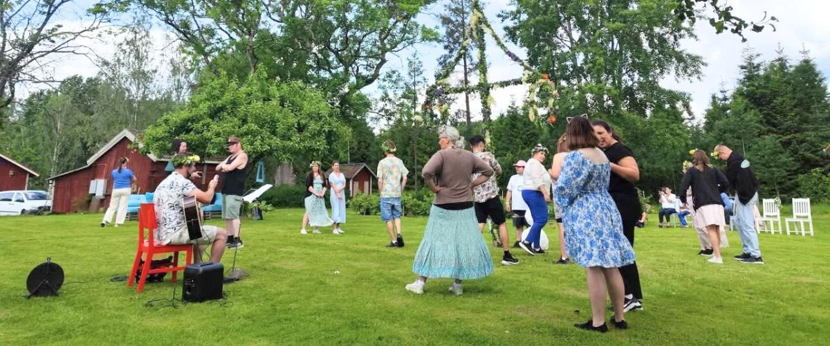 Midsommarfirande på Rasmusbyns gröna gård – en somrig samling av bybor, anhöriga och medarbetare på vårt LSS-boende.