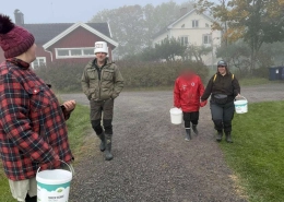 Bybor och personal promenerar tillsammans i höstdimma utanför Rasmusbyns socialterapeutiska LSS-boende.